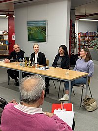 Vier Nachhaltigkeits-Botschafter sitzen bei einem Themenabend gemeinsam an einem Tisch